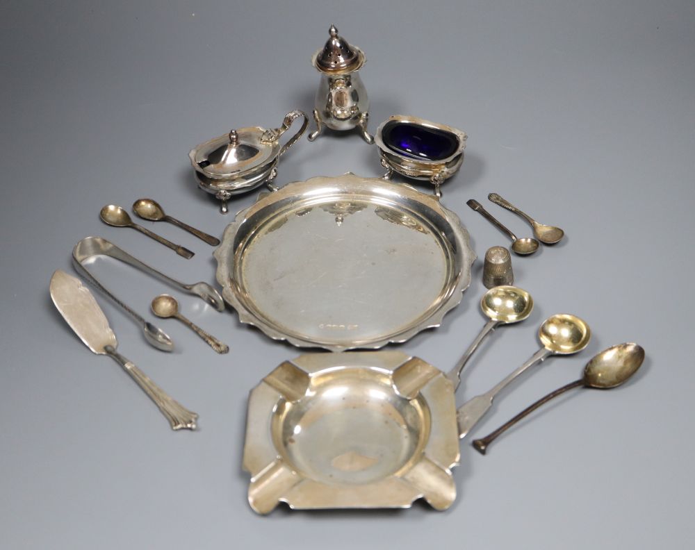 A group of small silverware including small waiter, three condiments, ashtray and minor flatware.